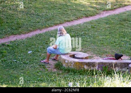 terni, italien juli 06 2020:Mann sitzt im Park in völliger Ruhe im Schatten Stockfoto