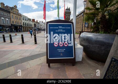 Ein Schild vor Cardiff Castle, das fordert, dass Menschen soziale Distanzierung praktizieren und maximal zwei Stunden bleiben, Juli 2020. Stockfoto