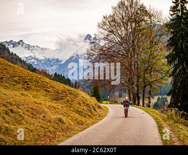 Nach der leichten Wanderung entlang der Oy von Oberstdorf bis zum Gasthof, geht es am besten mit Leih-Scootern auf den asphaltierten Rückweg. Oberstdorf, Deutschland Stockfoto
