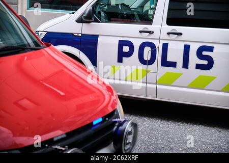 Das Feuerwehrauto mit blauem Licht und ein Polizeiauto auf der Straße in Finnland. Stockfoto