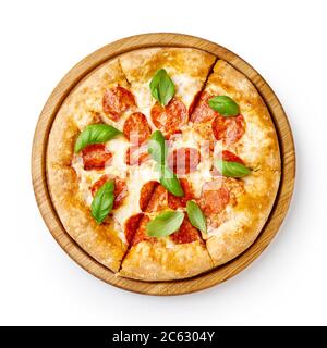 Pepperoni Pizza mit Basilikumblättern auf Holzbrett isoliert. Ansicht von oben auf Pizza in Scheiben. Stockfoto