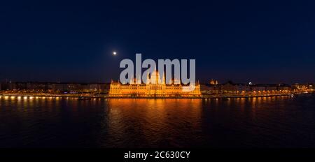 Panorama-Luftdrohne Aufnahme der Fassade des ungarischen Parlaments mit Licht in Budapest Nacht Stockfoto