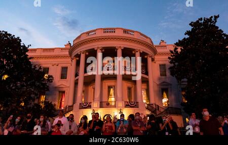 Gäste beobachten das Feuerwerk über der National Mall während der jährlichen Feier des Unabhängigkeitstages auf dem South Lawn des Weißen Hauses am 4. Juli 2020 in Washington, DC. Stockfoto