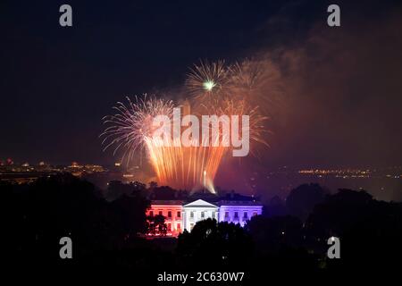 Das White House North Portico wurde in rot-weißen und blauen Lichtern beleuchtet, als während der jährlichen Unabhängigkeitstag-Feier auf dem South Lawn des Weißen Hauses am 4. Juli 2020 in Washington, DC, ein Feuerwerk über der National Mall explodierte. Stockfoto