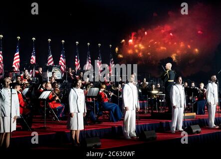 Feuerwerk explodiert über der National Mall, während die U.S. Marine Band während der jährlichen Feier des Unabhängigkeitstages auf dem South Lawn des Weißen Hauses am 4. Juli 2020 in Washington, DC, begleitet. Stockfoto