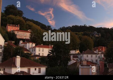 Sonnenuntergang in Sintra in Portugal. Blauer Himmel mit rosa Wolken und Dächer von Häusern in der Altstadt Sintra, Stockfoto