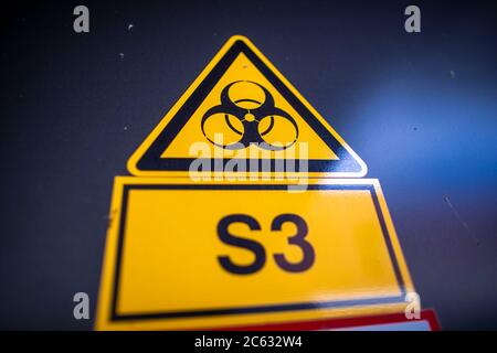 Riems, Deutschland. Juli 2020. Das Warnschild für Biogefährdung hängt an einer speziellen Schleusentür vor einem Labor der Sicherheitsstufe 3 in einem Laborgebäude des Friedrich-Loeffler-Instituts auf der Insel Riems. Die Bundesforschungsanstalt für Tiergesundheit hat die Aufgabe, einerseits die Gesundheit von lebensmittelproduzierenden Tieren zu erhalten und andererseits Menschen vor Zoonosen zu schützen. Das derzeit dringlichste Forschungsprojekt sind Tierversuche zur Erforschung des neuartigen Coronavirus. Quelle: Jens Büttner/dpa-Zentralbild/ZB/dpa/Alamy Live News Stockfoto