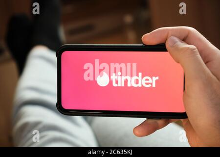 Tinder-Logo auf dem Smartphone-Bildschirm in mans Hand. Mann mit Zunder Anwendung für Dating und auf der Suche nach Liebe, Juli 2020, Prag, Tschechische Republik. Stockfoto