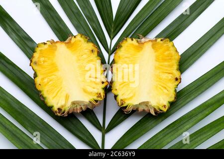 Reife Ananas auf tropischen Palmblättern. Draufsicht Stockfoto