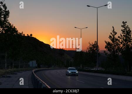 Ankara/Türkei-Juli 04 2020: Auto auf dem Verkehr und schöner Sonnenuntergang im Hintergrund zwischen Hügel Stockfoto