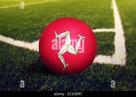 Isle of man Flagge auf Ball in der Ecke Kick Position, Fußballfeld Hintergrund. Fußball-Nationalthema auf grünem Gras. Stockfoto