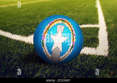 Nördliche Marianen Flagge auf Ball an der Ecke Kick Position, Fußballplatz Hintergrund. Fußball-Nationalthema auf grünem Gras. Stockfoto