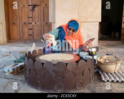 Frau, die ein traditionelles omanisches Frühstück im Nizwa Fort, Nizwa, Sultanat von Oman zubereitet. Stockfoto