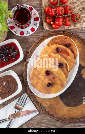 Schokoladen-Pfannkuchen mit Schokoladenglasur und Sauerkirsche. Selektiver Fokus Stockfoto