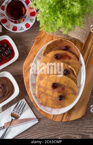 Schokoladen-Pfannkuchen mit Schokoladenglasur und Sauerkirsche. Selektiver Fokus Stockfoto