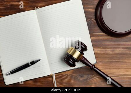 Richterhammer mit einem Notizbuch auf einem Holzhintergrund. Stockfoto