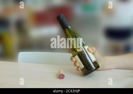 Frau Hand hält eine Flasche, während Wein gießt Stockfoto