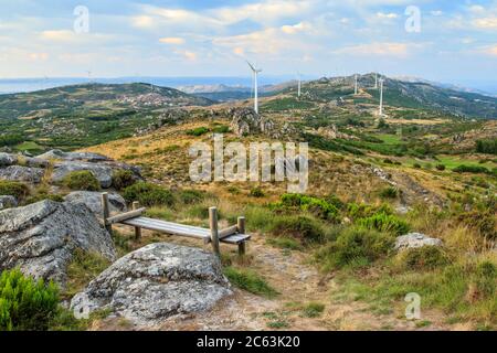 Schöne Landschaft von Serra do Caramulo in Portugal, bei Sonnenuntergang, mit Holzbank im Vordergrund als Aussichtspunkt für die lange Sicht. Stockfoto