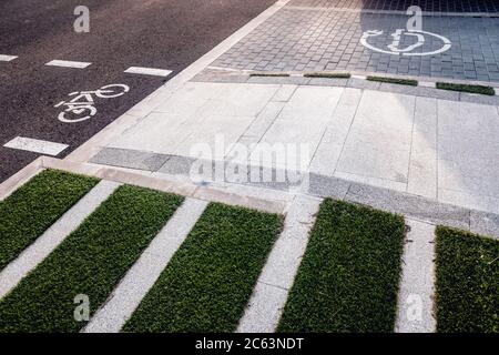 Neue Fahrradwege neben Ladestationen für Elektrofahrzeuge auf Asphalt. Stockfoto