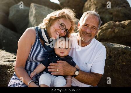 Großeltern Holding & Umarmenden Enkel Stockfoto