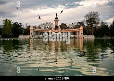 Reisende in der Nähe von altertüm Denkmal des Königs Alfonso XII in der Nähe Teich mit Vögeln in Retiro Park in Madrid Stockfoto