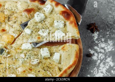 Pizza mit vier Käsesorten, italienische Pizza. Pizza gefüllt mit vier Sorten Käse auf einem grauen Hintergrund. Stockfoto