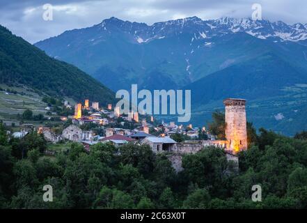 Dämmerung Blick auf die Swanetian Türme in Mestia mit dem mächtigen Kaukasus-Gebirge im Hintergrund, Svanetia, Georgien. Stockfoto