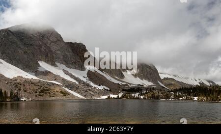 Der Lake Marie in Wyomings Snowy Range bleibt unter Sturmwolken ruhig. Stockfoto