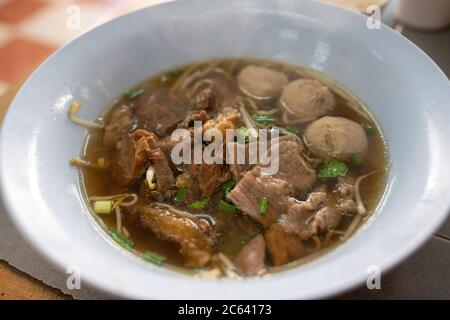Geschmorte Rindersuppe und Fleischbällchen in einer weißen Schüssel Nahaufnahme von oben ist ein beliebtes Street Food in Thailand. Stockfoto
