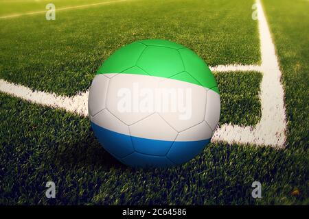 Sierra Leone Flagge auf Ball an der Ecke Kick Position, Fußballfeld Hintergrund. Fußball-Nationalthema auf grünem Gras. Stockfoto