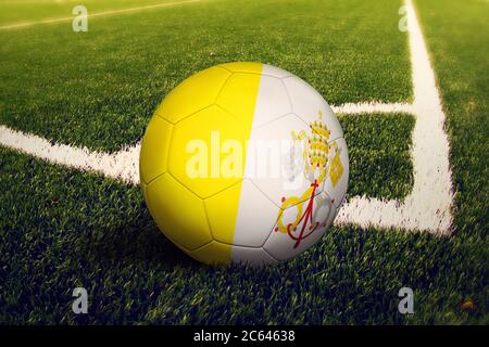 Vatikanstadt Flagge auf Ball an der Ecke Kick Position, Fußballfeld Hintergrund. Fußball-Nationalthema auf grünem Gras. Stockfoto