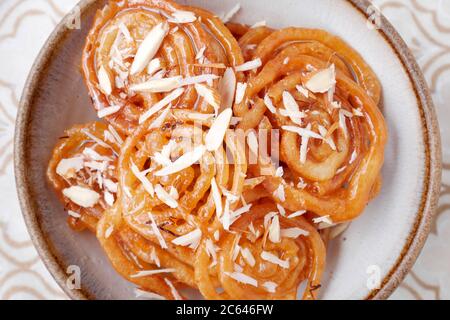 HAUSGEMACHTE JALEBI MIT MANDELFLOCKEN Stockfoto