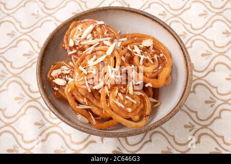 HAUSGEMACHTE JALEBI MIT MANDELFLOCKEN Stockfoto