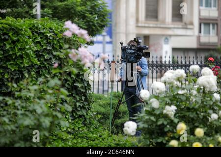 Fernsehkamerabetreiber filmt in einem Garten voller Blumen. Stockfoto