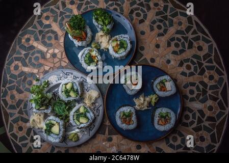 Hausgemachte vegane Sushi-Rollen mit Reis, Algen, Tofu, Avocado und anderen Geschmacksrichtungen. Stockfoto