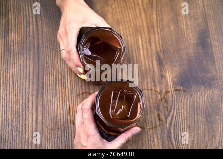 Ein Glas Kaffee auf Holzgrund. Ich war mit American im Cafe. Kühle Sommergetränke. Whiskey Coctail, Kaffee-basierte Alkoholcocktails und Longdrinks Stockfoto