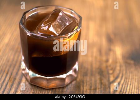 Ein Glas Kaffee auf Holzgrund. Ich war mit American im Cafe. Kühle Sommergetränke. Whiskey Coctail, Kaffee-basierte Alkoholcocktails und Longdrinks Stockfoto