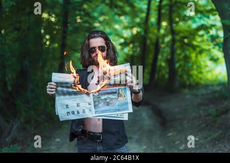 Bärtiger Mann mit brennender Zeitung Stockfoto