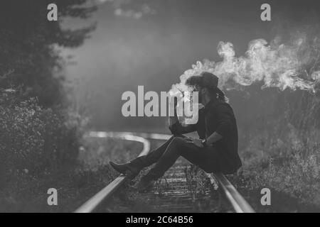 Cowboy raucht eine Zigarette auf der Bahnlinie Stockfoto