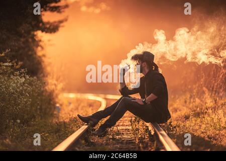 Cowboy raucht eine Zigarette auf der Bahnlinie Stockfoto