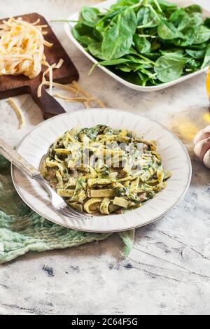 Tagliatelle Pasta mit Spinat und Pilzen auf einem Teller. Vegetarisches Essen Stockfoto