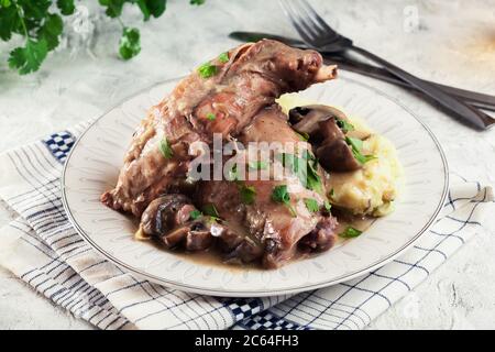 Geschmorte Kaninchenbeine mit Gemüse auf einem Teller Stockfoto
