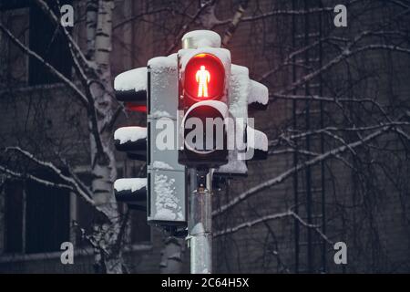 Schneebedeckte rote Ampel für Fußgänger, Finnland. Stockfoto