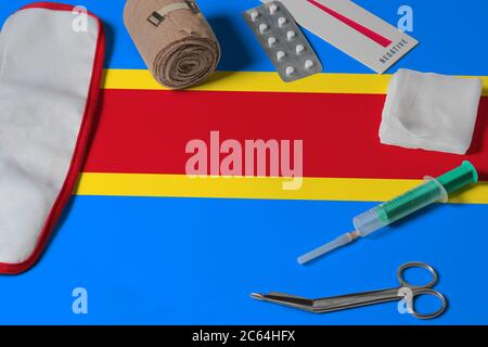 Kongo-Flagge mit erste-Hilfe-medizinischen Kit auf Holztisch Hintergrund. Nationales Gesundheitssystem Konzept, medizinisches Thema. Stockfoto