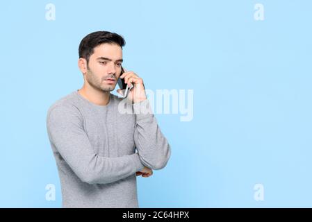 Porträt von schweren gut aussehenden kaukasischen Mann mit Gespräch am Telefon in isolierten Studio blauen Hintergrund Stockfoto