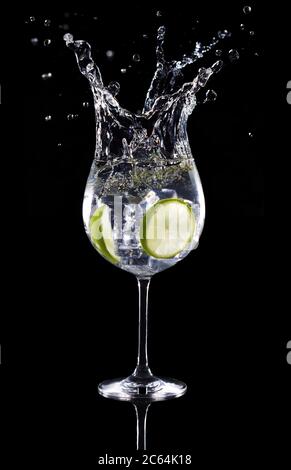 gin Tonic Cocktail spritzt isoliert auf schwarzem Hintergrund Stockfoto