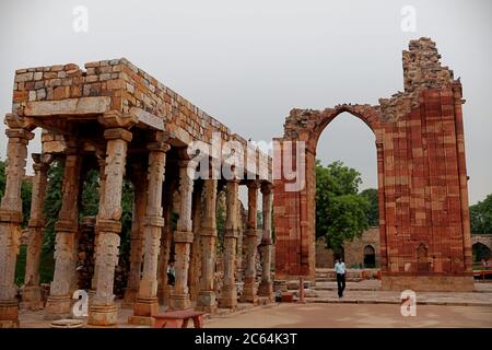 Ein Sicherheitsbeamter, der unter der Quwwat-al-Islam Moschee steht, baut im Qutb Minar Komplex, Mehrauli, Delhi, Indien. Stockfoto