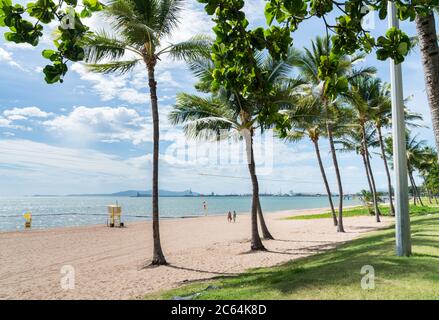 Touristen, die im Herbst einen Spaziergang am sonnigen Strand in Townsville, Queensland, Australien, genießen Stockfoto