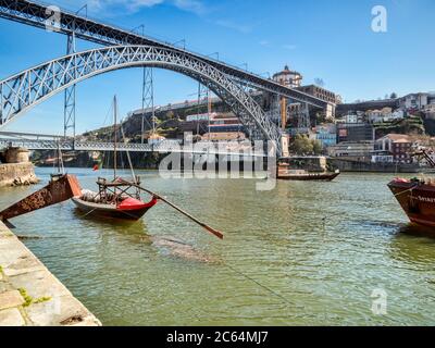 10. März 2020: Porto, Portugal - die Luis I Brücke, eine Straße und Bahnübergang des Douro Flusses in Porto, mit traditionell gestalteten Booten. Stockfoto