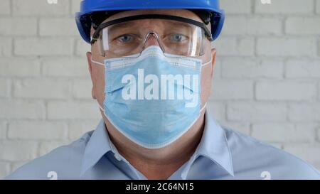 Ingenieur mit Sicherheitshelm und Schutzmaske auf seinem Gesicht im Gespräch mit dem Handy Stockfoto